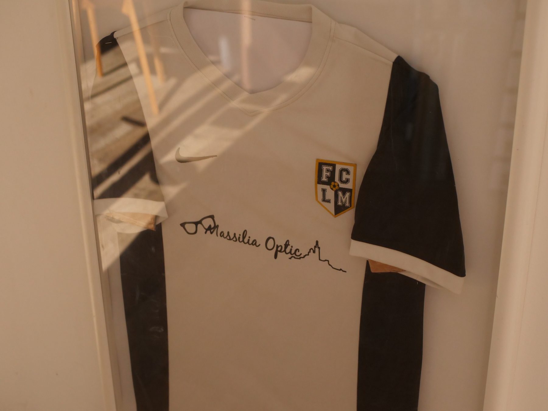 Le maillot floqué Massilia Optic accroché dans la boutique